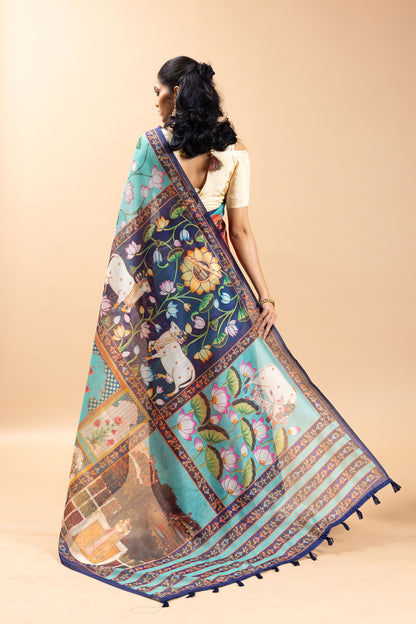 Woman wearing a colorful saree with floral and animal patterns on a beige background Shringar Pichwai Chanderi Saree | yuvani vesture