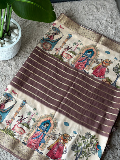 A jacquard silk blend saree with a traditional design featuring characters and patterns, laid out on a floor next to a potted plant. Sundar Kahani jacquard silk saree.
